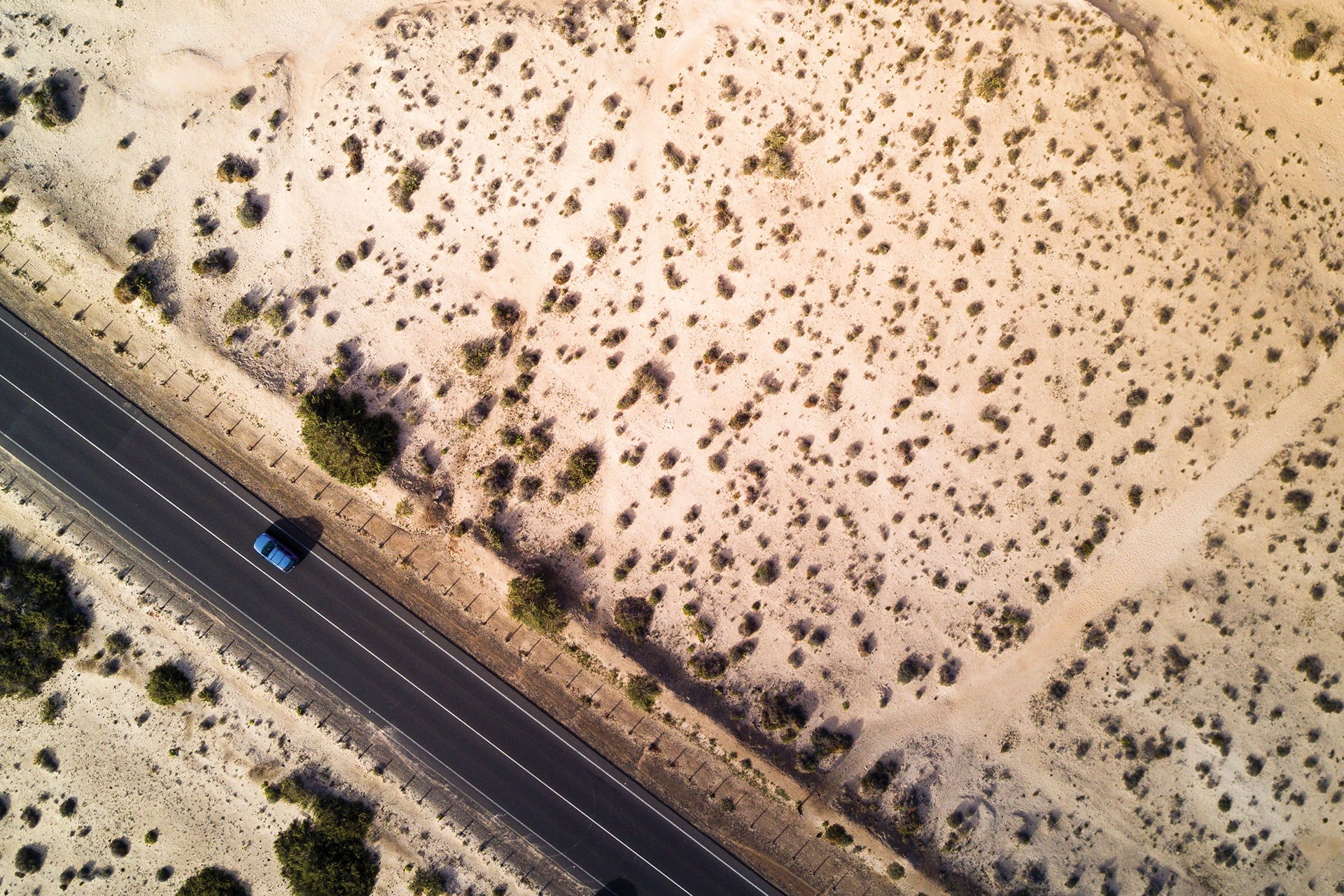 Aerial view of a single car on a desert highway