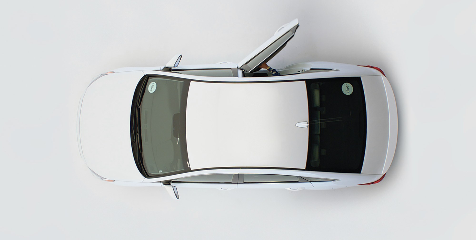 A top-down view of a white car with Uber decals — the Fair x Uber rideshare program