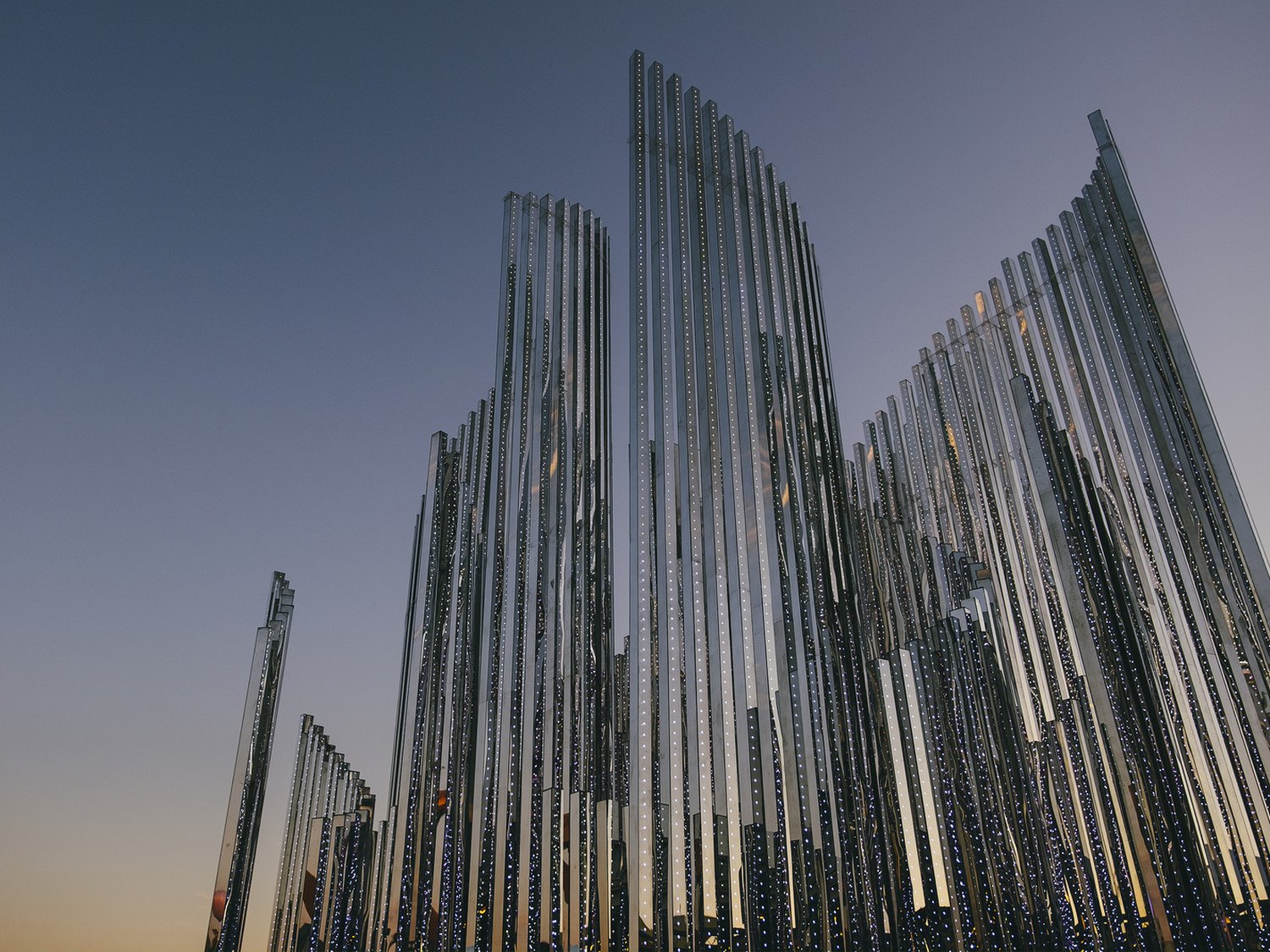 Mirror-clad spires inspired by the curved pipes of a church organ